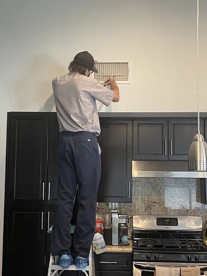 Technician inspecting an air vent during HVAC service in Marlow Heights